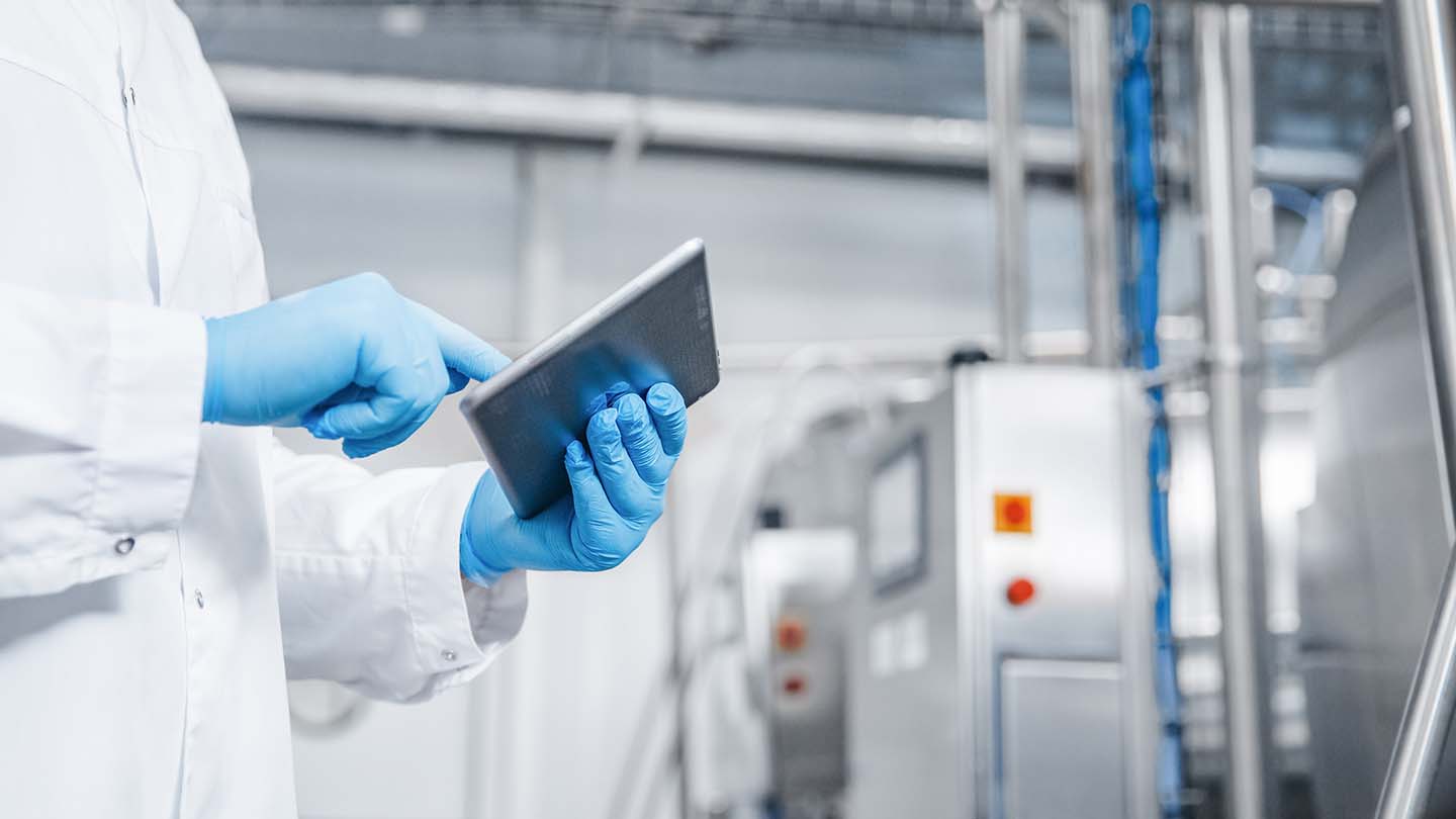 Quality inspector working on tablet in a manufacturing plant